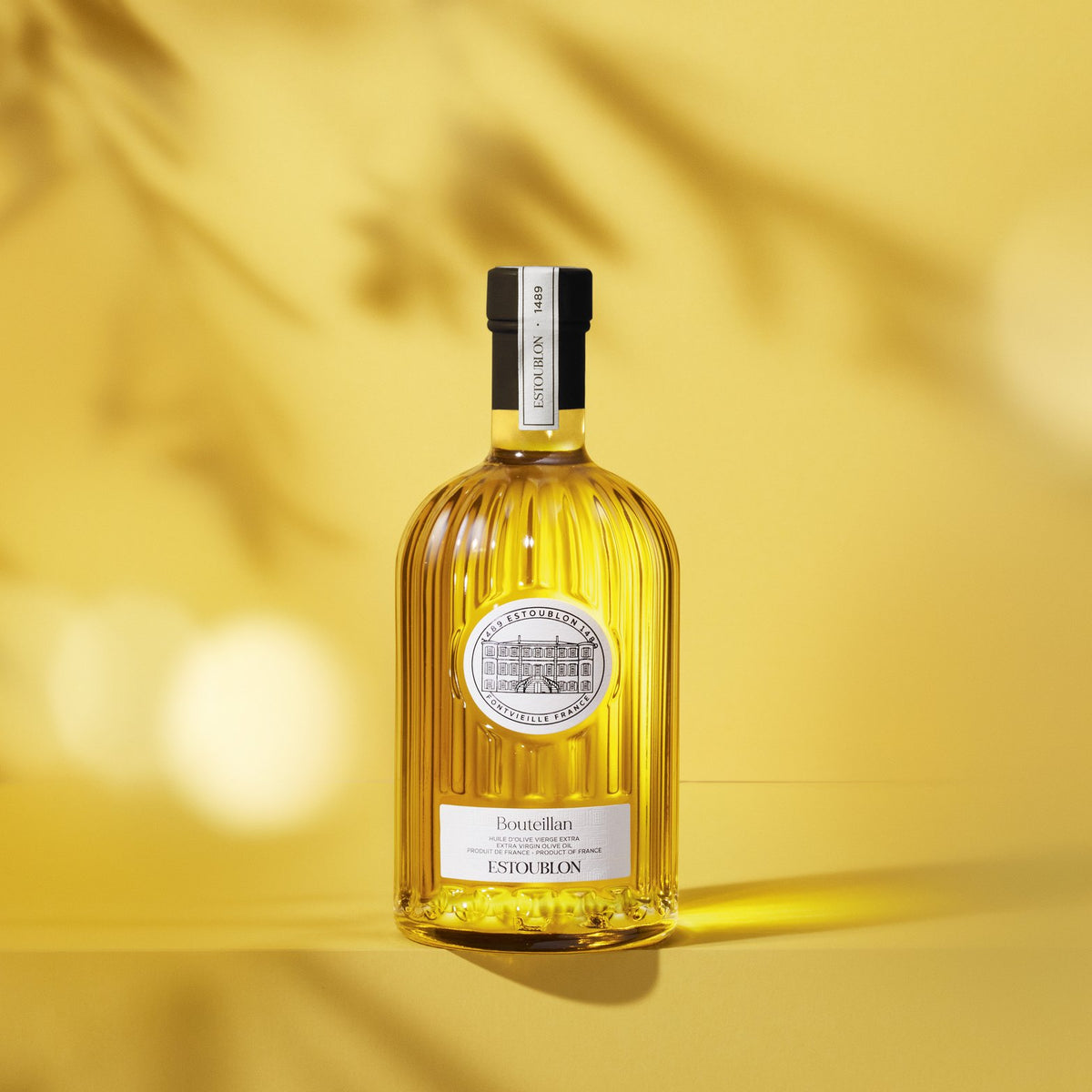 Bouteillan single-variety olive oil by Château d'Estoublon, styled on a yellow background