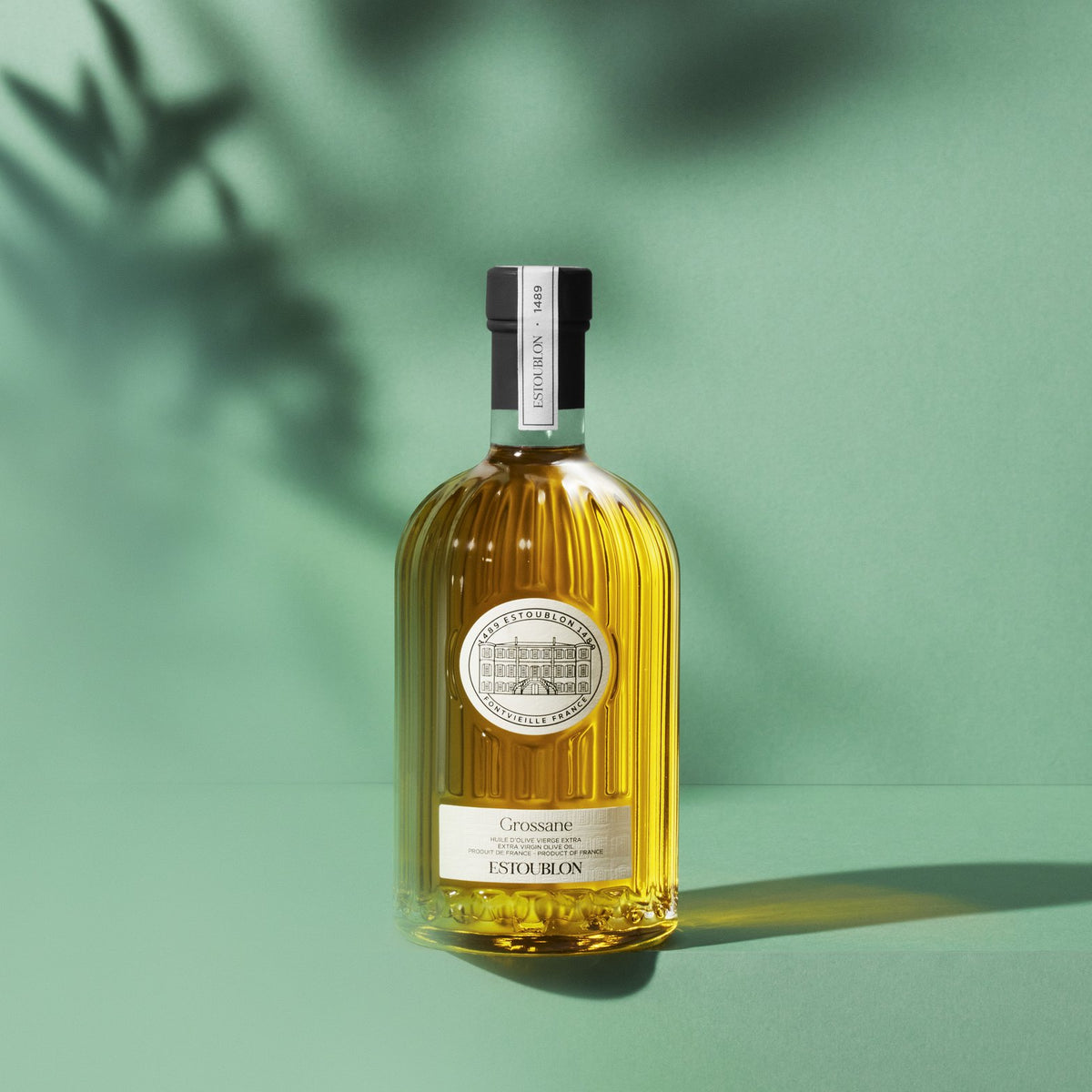 Grossane single-variety olive oil by Château d'Estoublon, styled on a green background
