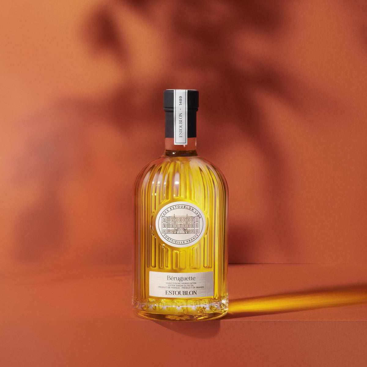 Béruguette single-variety olive oil by Château d'Estoublon, styled on a terracotta background