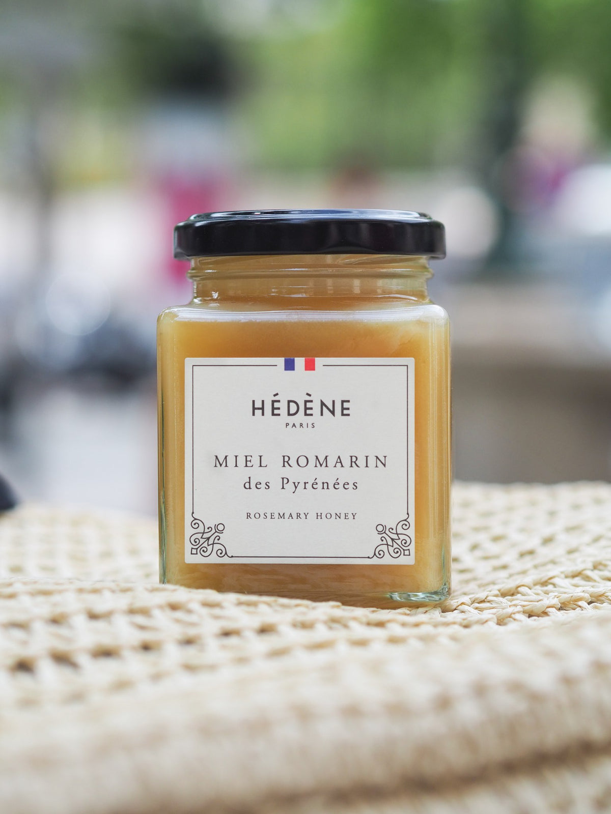 Pot de miel de romarin des Pyrénées Hédène sur un tissu tissé