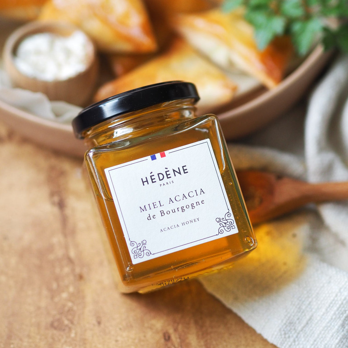 Hédène acacia honey jar on a wooden board with tapas