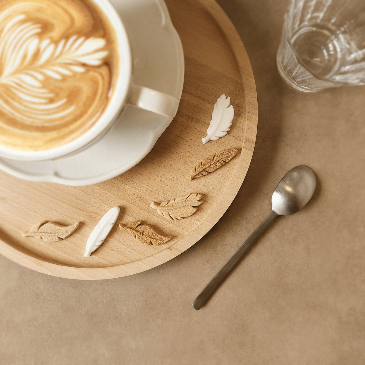 Sucres Canasuc L’Air de Rien en forme de plume à côté d’un café latte