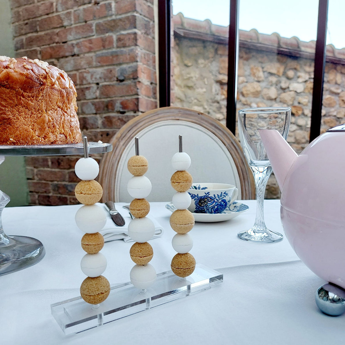 Perles de sucre Le Boulier Canasuc sur des bâtonnets, à côté d’une tasse