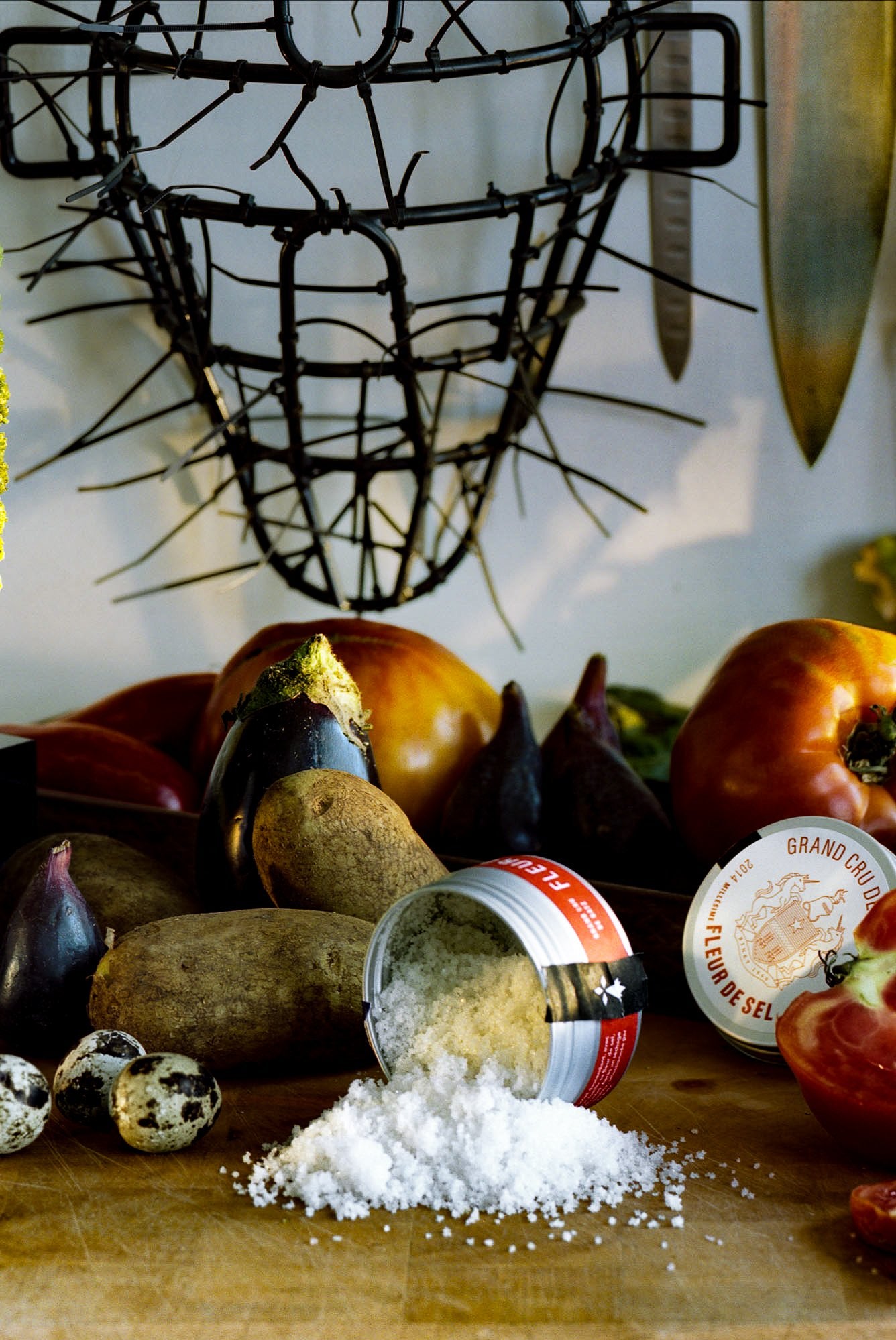 Binet 1660 fleur de sel spilling from its tin beside fresh vegetables